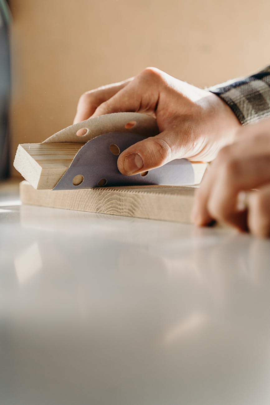 a person using a sandpaper on a piece of wood